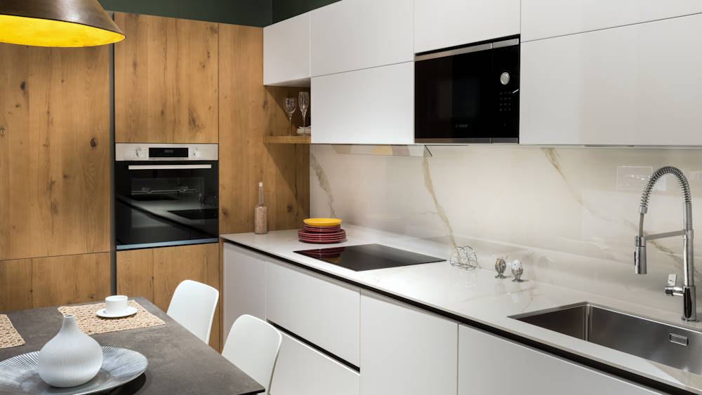 Modern kitchen furnished with white wooden cabinets and platform in light