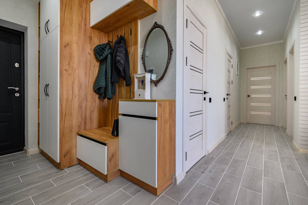 Small entrance hallway interior with shoe storage, hanger stand and mirror
